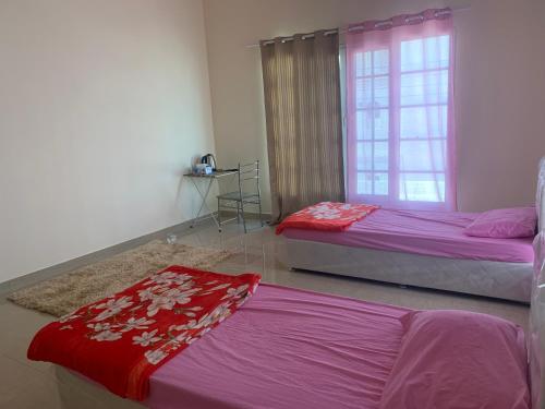 a bedroom with two beds and a window at Jonoob hostel in Muscat