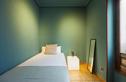 1 dormitorio con 1 cama en una pared verde en Ideal Hostel Madrid, en Madrid