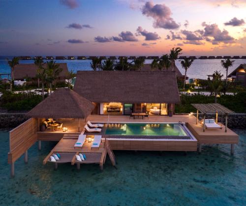 a villa with a swimming pool and a resort at Waldorf Astoria Maldives Ithaafushi in South Male Atoll