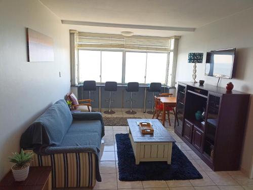 a living room with a couch and a tv and a table at Driftsands 23 in Doonside