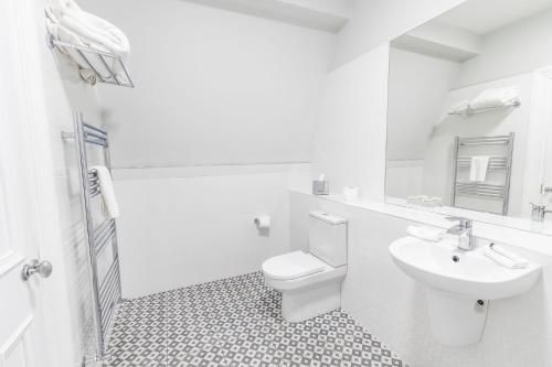 een witte badkamer met een toilet en een wastafel bij Mulranny Park Hotel in Mulranny