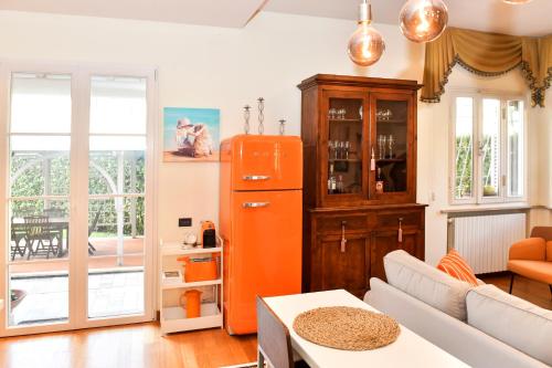 an orange refrigerator in a living room with a couch at Il Villino di Monic Pisa centro in Pisa