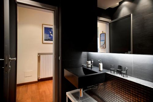 W łazience znajduje się czarna umywalka i lustro. w obiekcie Il Villino di Monic w Pizie