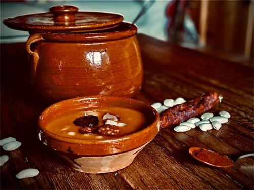 a wooden table with a bowl of soup and pills at Casa Rural Fuente del Arca Montejo in Montejo de la Sierra