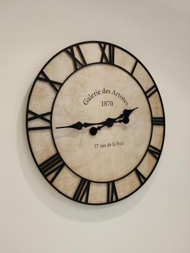 a clock that is on a wall at Le Beau Refuge Parisien de Cergy - Parisian modern flat at Cergy in Cergy