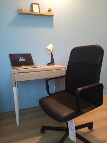 a desk with a chair and a laptop computer at Le Beau Refuge Parisien de Cergy - Parisian modern flat at Cergy in Cergy