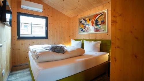 ein Schlafzimmer mit einem Bett in einem Holzzimmer in der Unterkunft FBA Village in Bundenthal