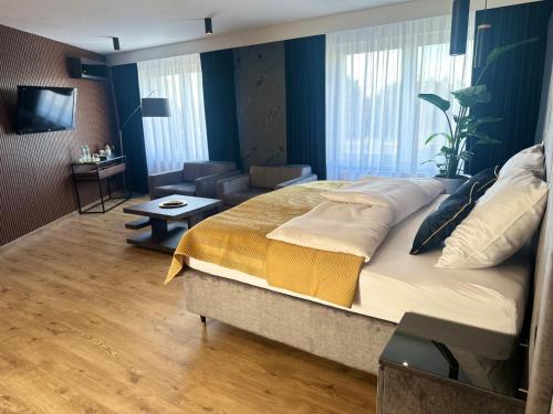 a bedroom with a large bed and a living room at Platinum in Budzyń