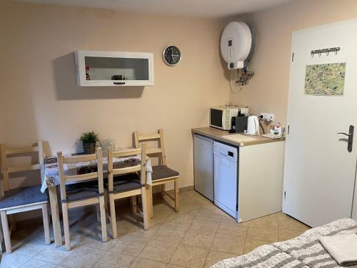 a kitchen with a table and a small kitchen with a microwave at Chatky U Davida Máchovo jezero in Doksy