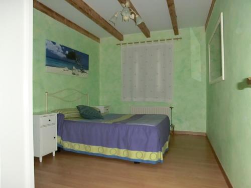 a bedroom with a bed in a room with green walls at El Establo,Casa rural in Busto de Bureba
