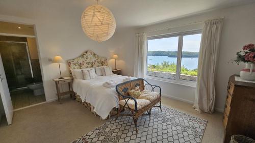 a bedroom with a bed and a large window at Fiddlers Green in Saint Mawes