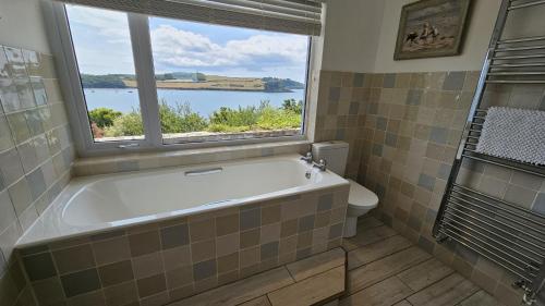 a bathroom with a bath tub and a window at Fiddlers Green in Saint Mawes