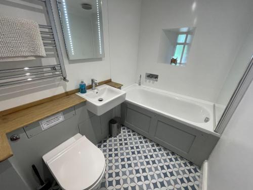 a bathroom with a toilet and a tub and a sink at Crugsillick Studio in Veryan