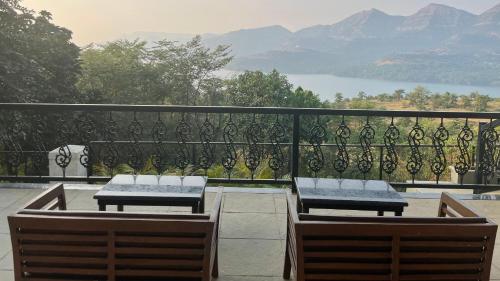 a balcony with two benches and a view of the mountains at The Green Gate Resort Mulshi in Pune