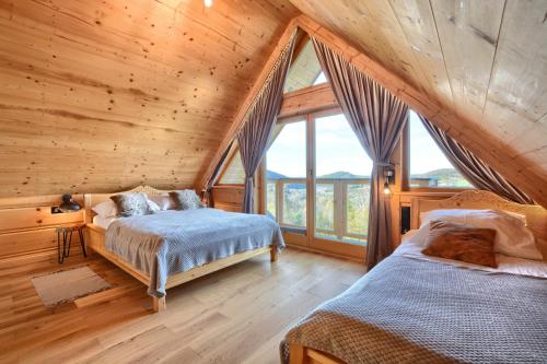 um quarto com 2 camas num chalé de madeira em Santa Angela Solina Centrum - Zapora em Solina