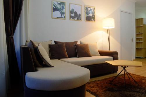 a living room with a couch and a table at Ameri Plaza Green Apartments in Tbilisi City