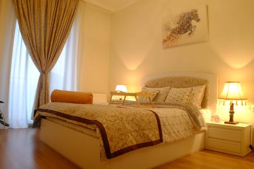 a bedroom with a bed and a window at Ameri Plaza Green Apartments in Tbilisi City