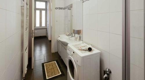 uma casa de banho com um lavatório e uma máquina de lavar roupa em Flarent Economy Apartments em Viena