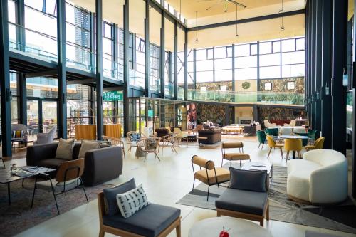 a lobby with chairs and tables in a building at Royal Green Wellness Resort in Moka
