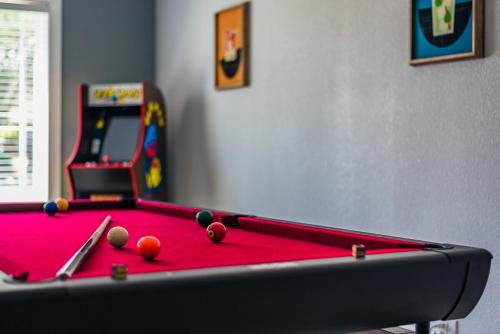 a pool table with balls and a video game at Gameroom, Bbq & Hot-tub By Lackland & Seaworld in San Antonio