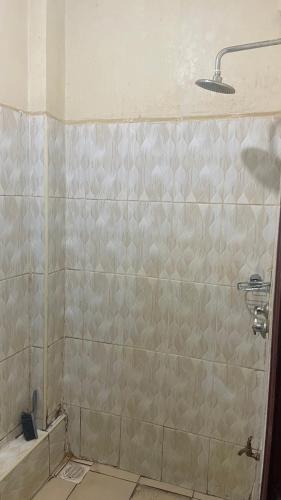 a bathroom with a shower with a tiled wall at Zuhura homes in Ruiru