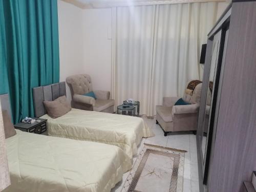 a hotel room with two beds and two chairs at Yaso Roof & Apartments in Amman