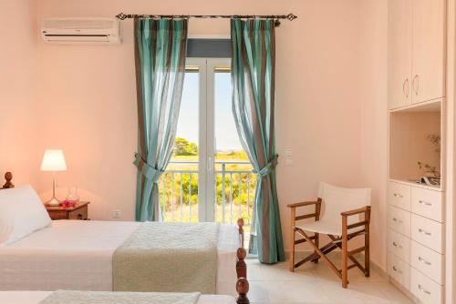 a bedroom with two beds and a window and a chair at Villa Aquamarine in Kounopetra