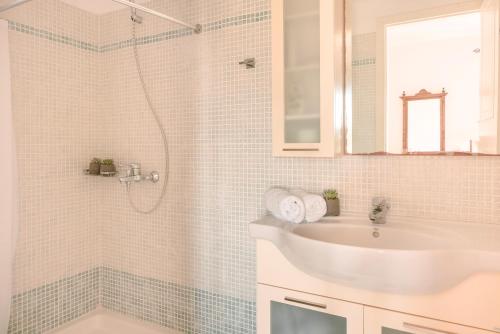 a white bathroom with a sink and a shower at Villa Aquamarine in Kounopetra