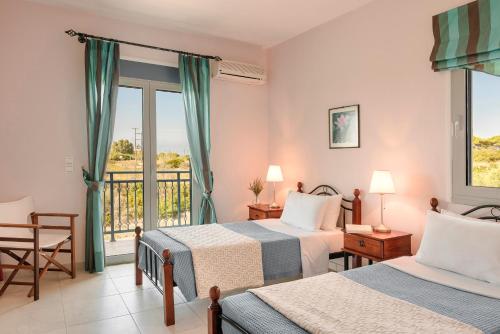 a hotel room with two beds and a balcony at Villa Sapphire in Kounopetra