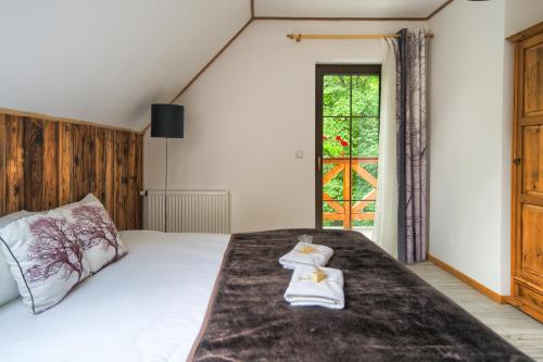 a bedroom with a bed with two towels on it at Tarninowe Wzgórze in Kunkowa