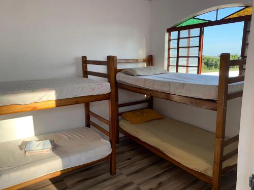 een kamer met 3 stapelbedden en een raam bij Casa de Campo e Pesqueiro in Pôrto Feliz