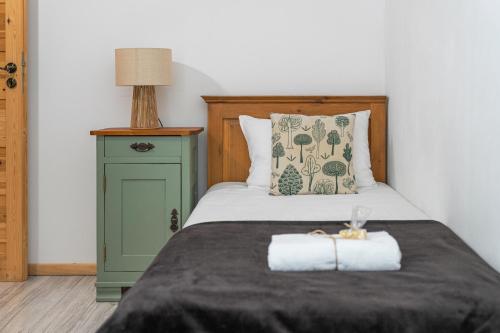 a bed with a wooden headboard and a green night stand at Tarninowe Wzgórze in Kunkowa