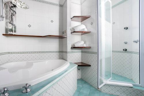 La salle de bains blanche est pourvue d'une baignoire et d'une douche. dans l'établissement Homescape Frascati, à Frascati