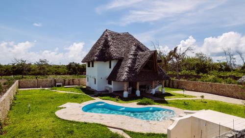 a small house with a pool in the yard at Nyuso za Afrika in Watamu