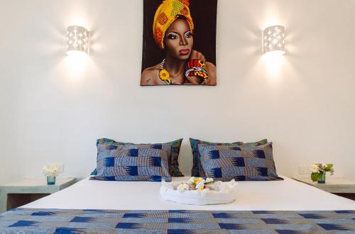 a bedroom with a bed with a picture of a woman at Nyuso za Afrika in Watamu