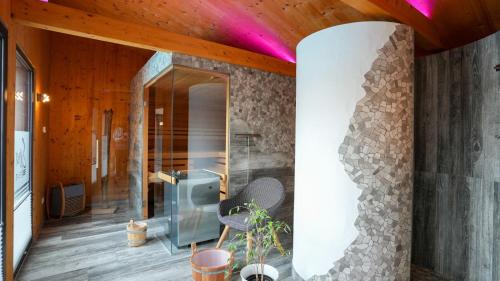 a bathroom with a glass shower and a stone wall at FBA Village in Bundenthal