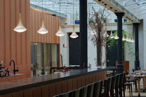 a restaurant with a bar with chairs and lights at Hotel Pod Różą in Kraków