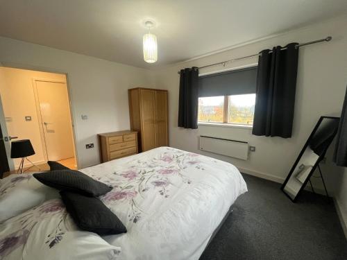 a bedroom with a large white bed with flowers on it at Deluxe Large Apartment Opposite Hepworth Gallery in Wakefield