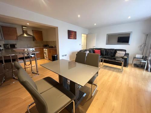 a living room and kitchen with a table and chairs at Deluxe Large Apartment Opposite Hepworth Gallery in Wakefield