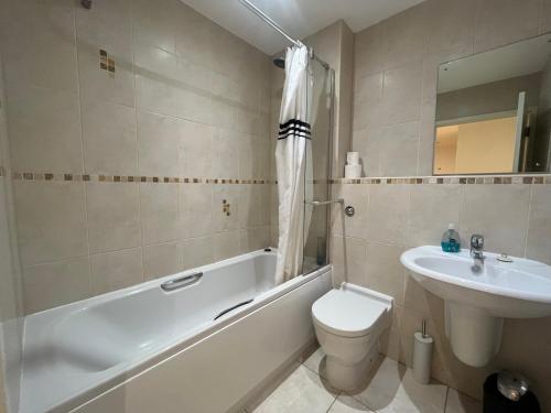 a bathroom with a tub and a toilet and a sink at Deluxe Large Apartment Opposite Hepworth Gallery in Wakefield