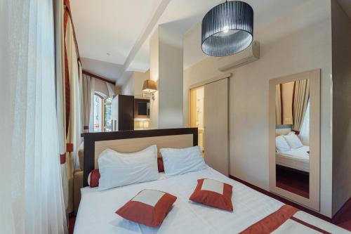 a bedroom with a bed with two pillows and a mirror at Boutique Hotel Palais Royal in Odesa