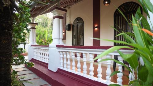 a porch of a house with a white railing at 4BHK Private Pool villa in North Goa with Kayaking nearby!! in Moira