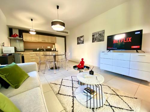 un salon avec un canapé et une télévision dans l'établissement Le Pearl By SCLS Locations, à Cannes