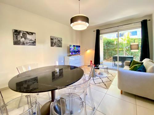 un salon avec une table et un canapé dans l'établissement Le Pearl By SCLS Locations, à Cannes