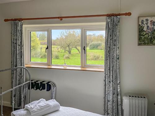 a bedroom with a window with curtains and a bed at Edgecoombe in Shaftesbury