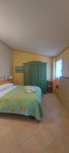 a bedroom with a large bed with a green headboard at B&B Dei Doria in Dolceacqua
