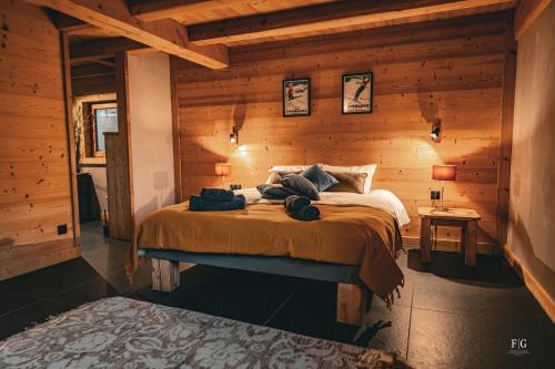 ein Schlafzimmer mit einem Bett in einem Holzzimmer in der Unterkunft Le Chalet de Vincent in Cordon