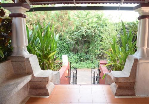 an open gate to a garden with plants at 4BHK Private Pool villa in North Goa with Kayaking nearby!! in Moira