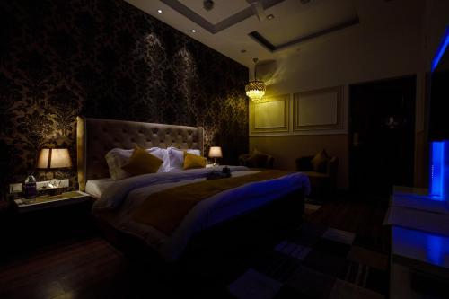a bedroom with a large bed in a dark room at Victorian Elegance Luxury Stays in Amritsar