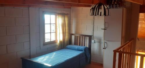 een kamer met een bed in een kamer met een raam bij Cabaña La Rosita in Villa Quillinzo